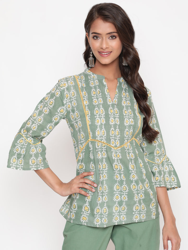 Woman posing in Savi's Cotton Printed Sage green flared sleeveless top.
