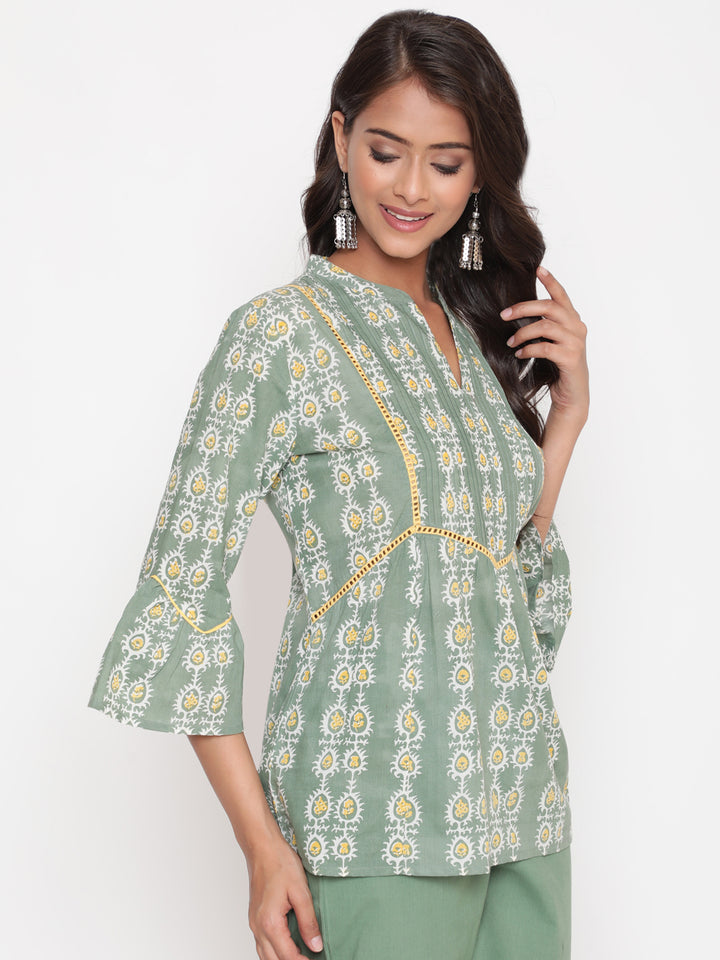 Woman posing in Savi's Cotton Printed Sage green flared sleeveless top.