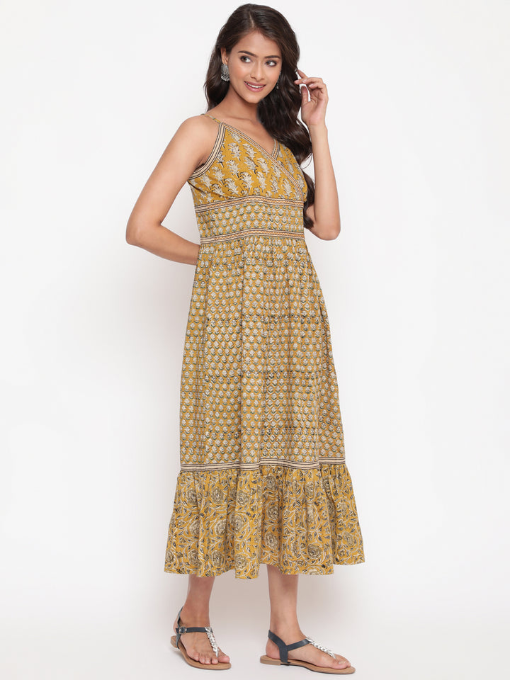 Woman posing in Savi's Cotton hand block inspired printed strappy mustard flared dress