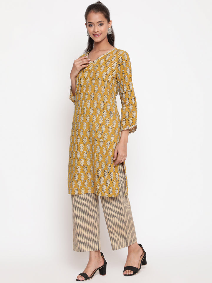 Woman posing in Savi's Cotton Printed Yellow Kurta Pant set