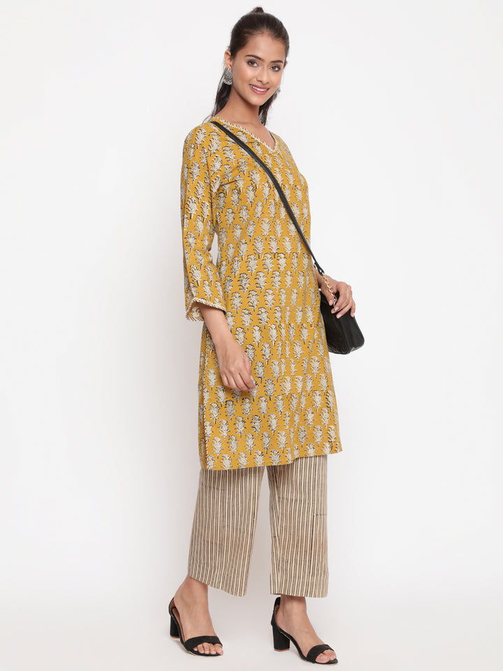 Woman posing in Savi's Cotton Printed Yellow Kurta Pant set