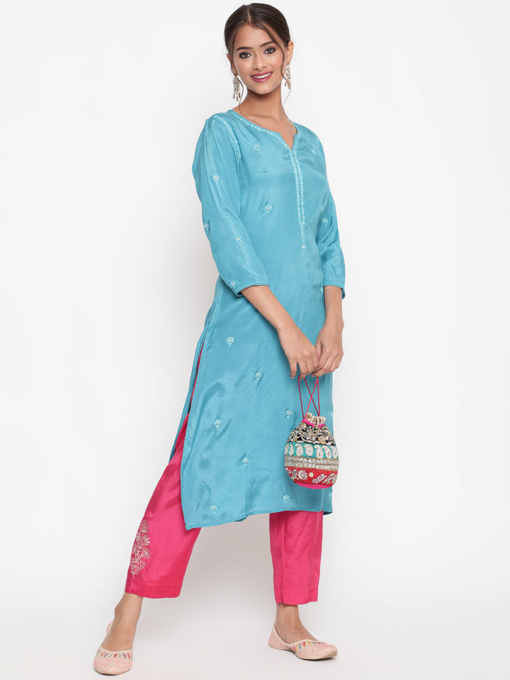Woman posing in Savi’s Shantoon Embroidered straight Blue Kurta with Pink Pant