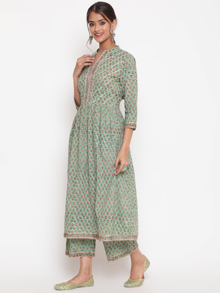 Woman posing in Savi's Cotton Embellished Sage Green A Line Flared Kurta pant Set