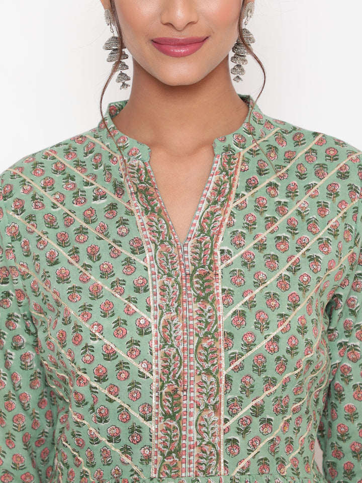 Woman posing in Savi's Cotton Embellished Sage Green A Line Flared Kurta pant Set
