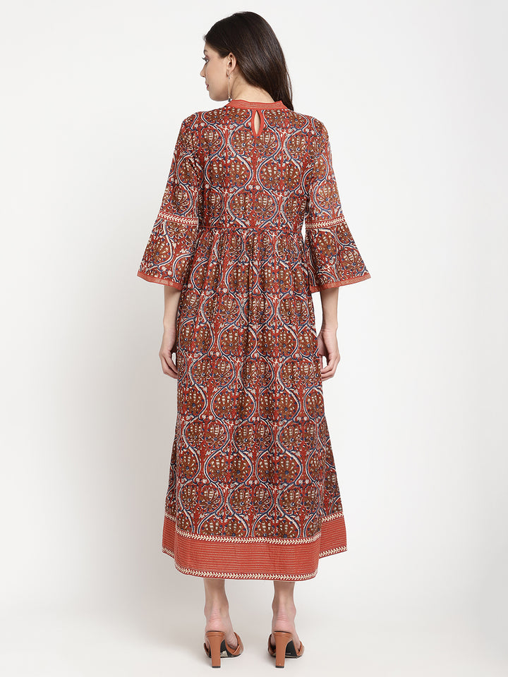Woman posing in a rust flared dress against a white background.