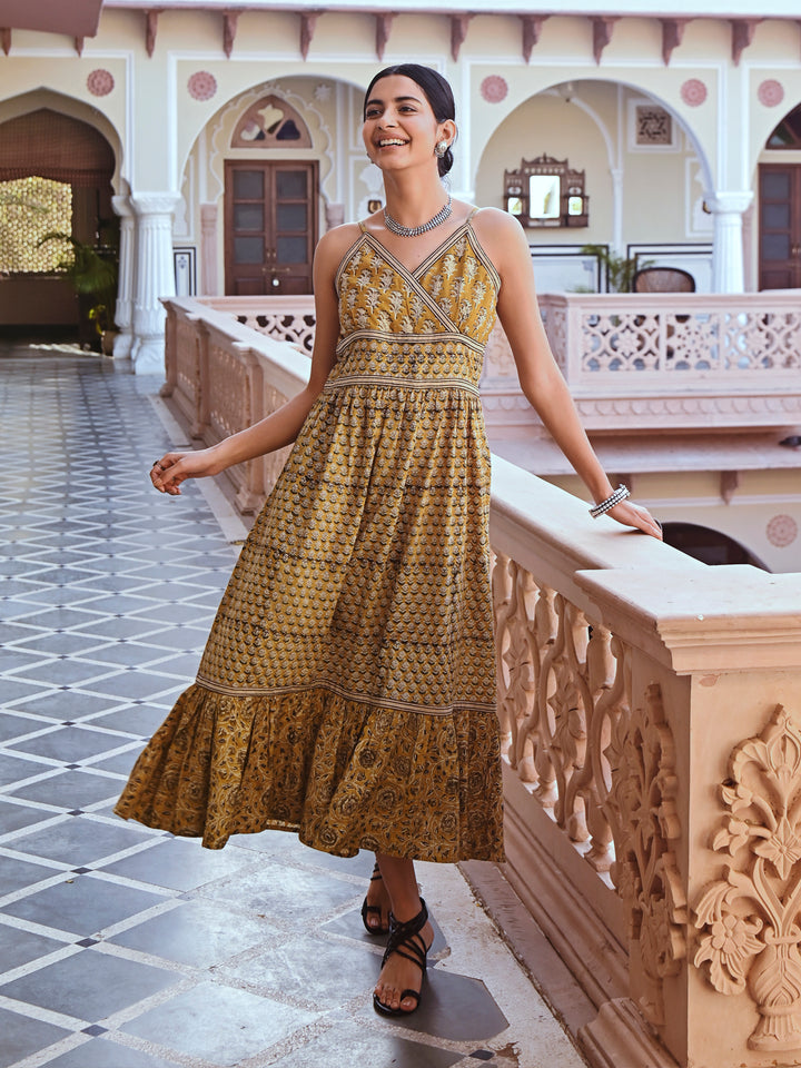 Woman posing in Savi's Cotton hand block inspired printed strappy mustard flared dress