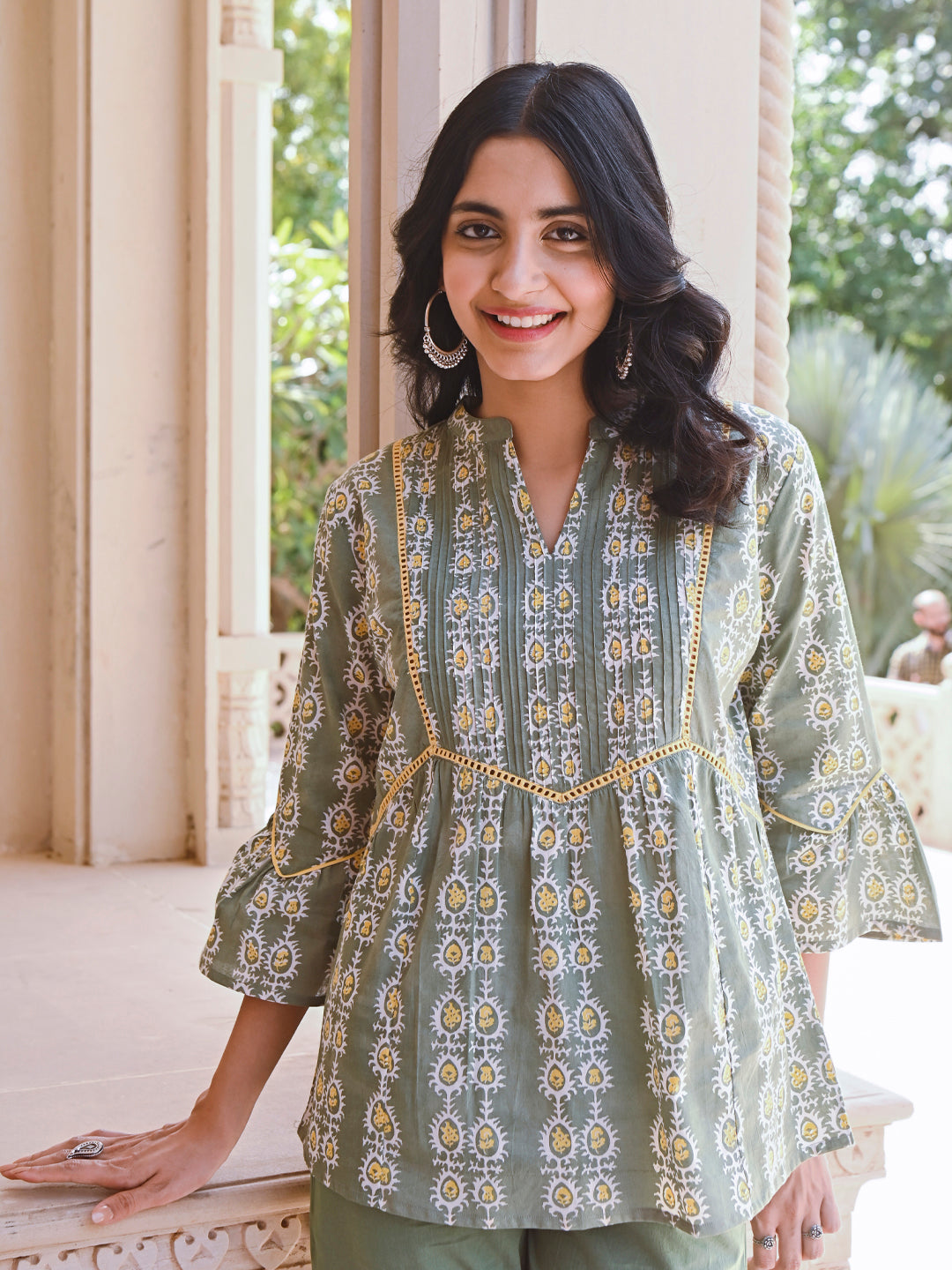 Woman posing in Savi's Cotton Printed Sage green flared sleeveless top.