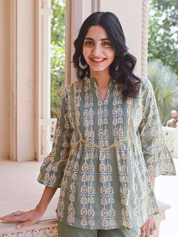 Woman posing in Savi's Cotton Printed Sage green flared sleeveless top.