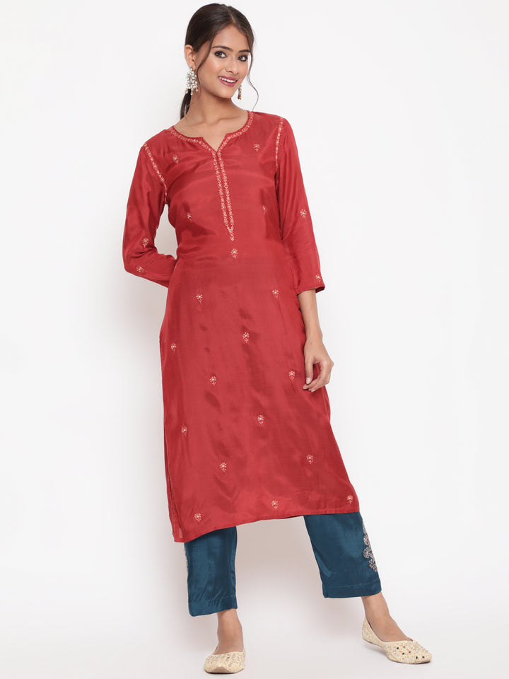Woman posing in Savi’s Shantoon Embroidered Ethnic Rust Kurta with Contrast Pant Set
