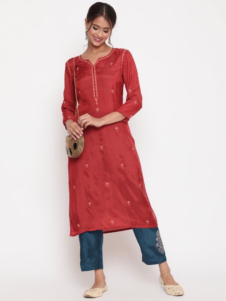 Woman posing in Savi’s Shantoon Embroidered Ethnic Rust Kurta with Contrast Pant Set