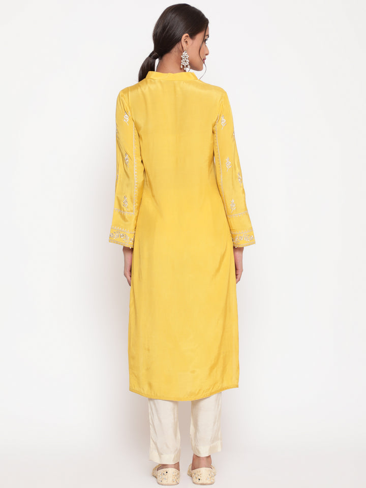 Woman posing in Savi’s Shantoon Embroidered Mustard Straight Kurta With Solid Pant