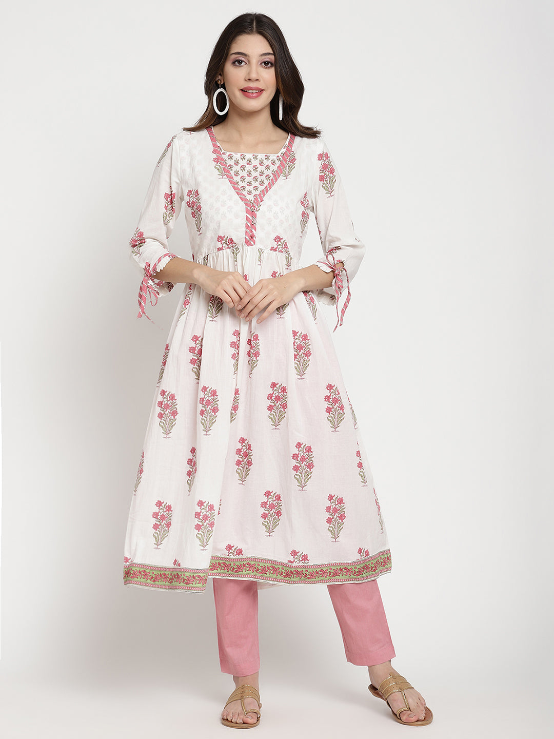 Woman posing in a white cotton Kurta that has a flared hemline.