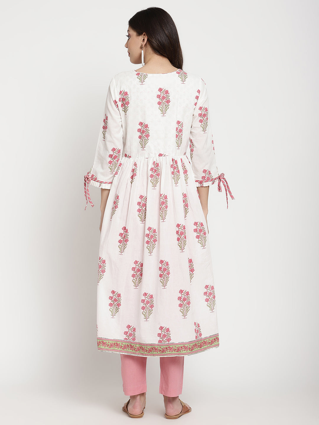 Woman posing in a white cotton Kurta that has a flared hemline.