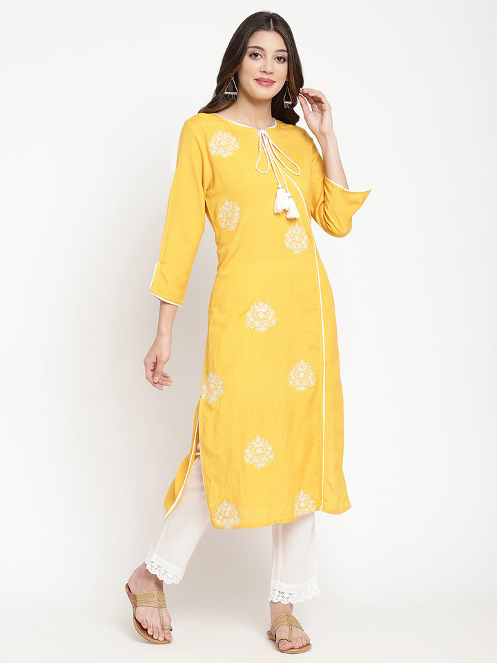 'Woman posing in yellow embroidered Angrakha Kurta Pant Set.