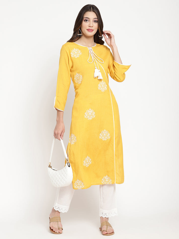 'Woman posing in yellow embroidered Angrakha Kurta Pant Set.