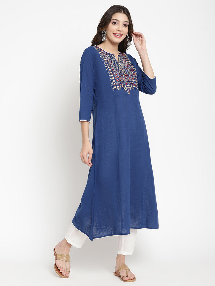 Woman posing in a blue embroidered Kurta by Savi. 