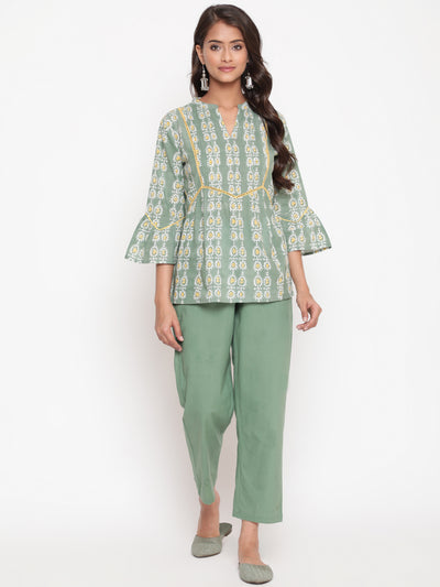 Woman posing in Savi's Cotton Printed Sage green flared sleeveless top.