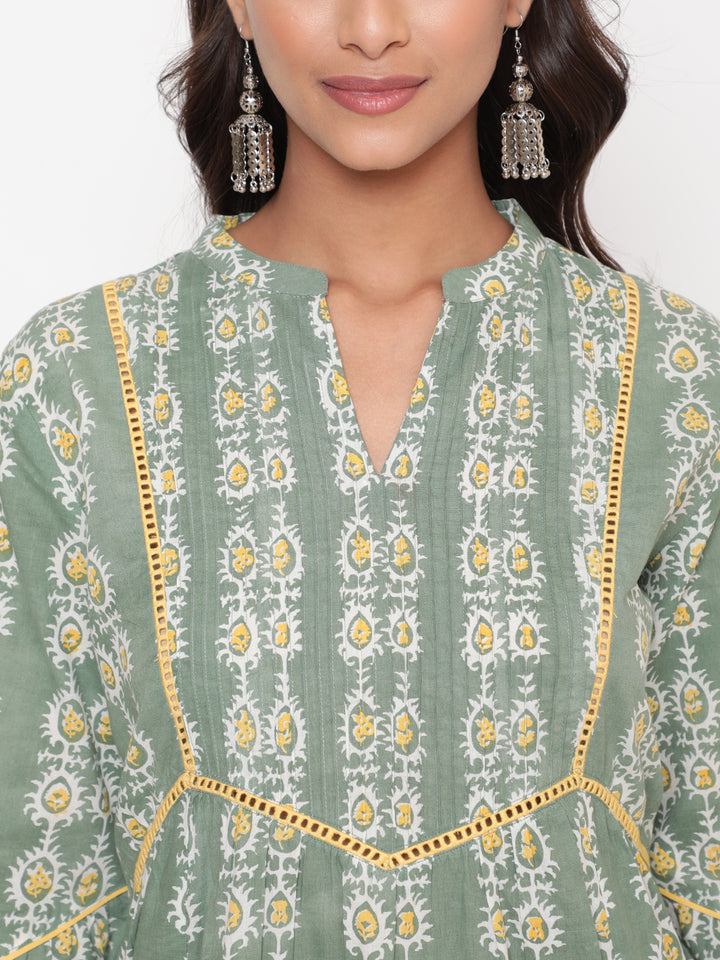 Woman posing in Savi's Cotton Printed Sage green flared sleeveless top.
