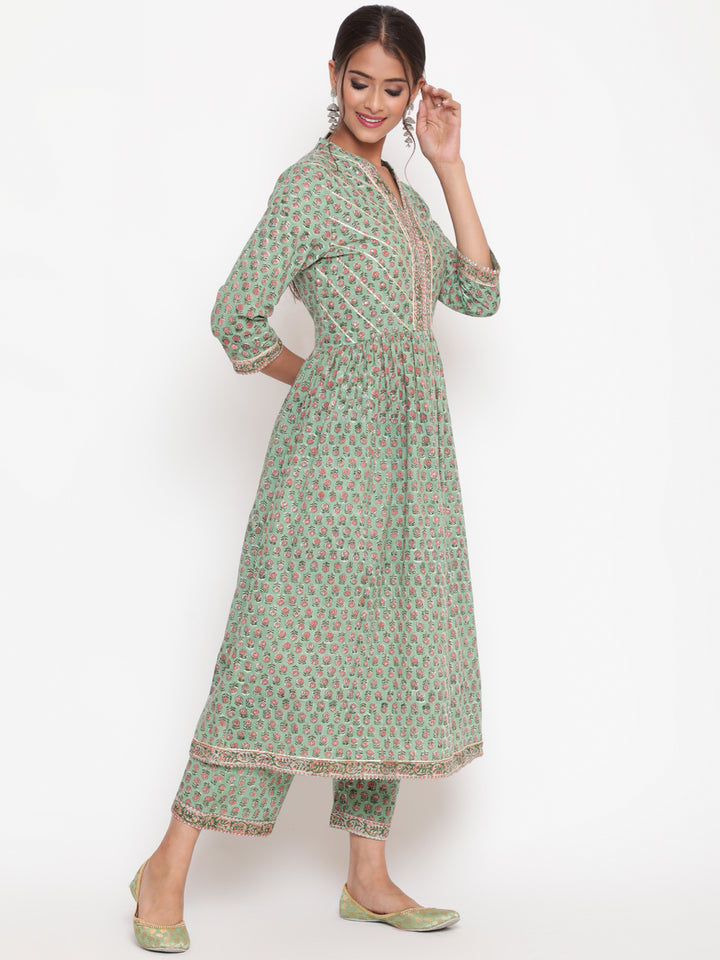 Woman posing in Savi's Cotton Embellished Sage Green A Line Flared Kurta pant Set