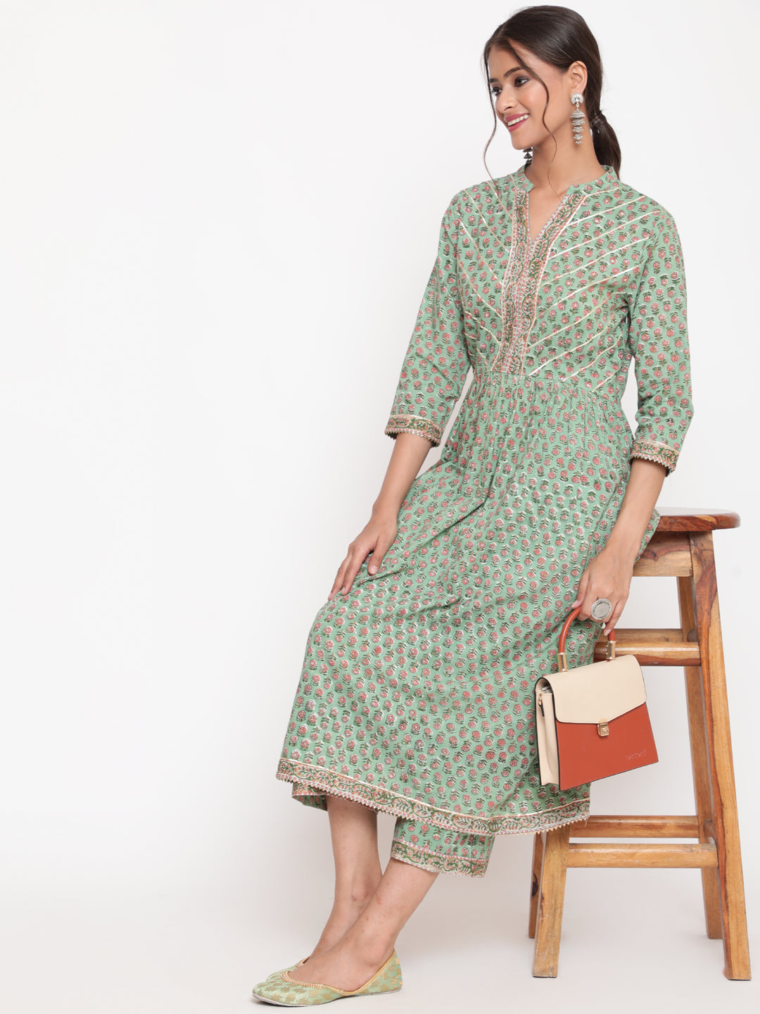"Woman posing in Savi's Cotton Embellished Sage Green A Line Flared Kurta pant Set "