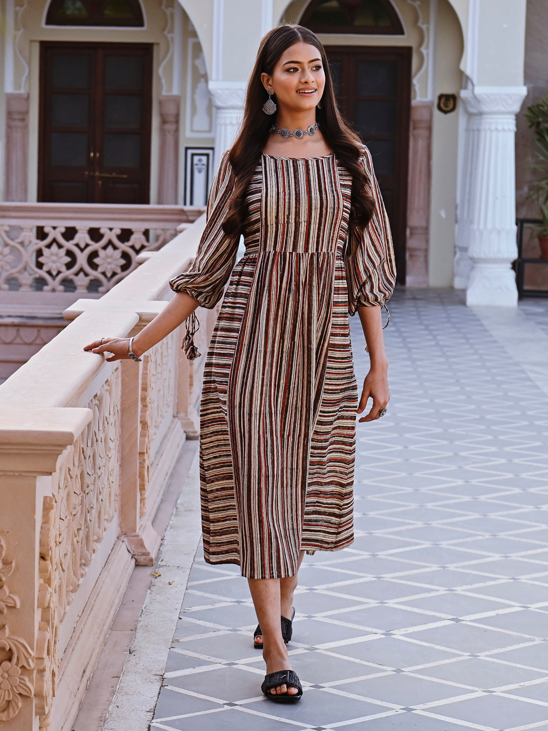 Woman posing in Savi's Cotton Block Printed tie up striped rust calf length dress