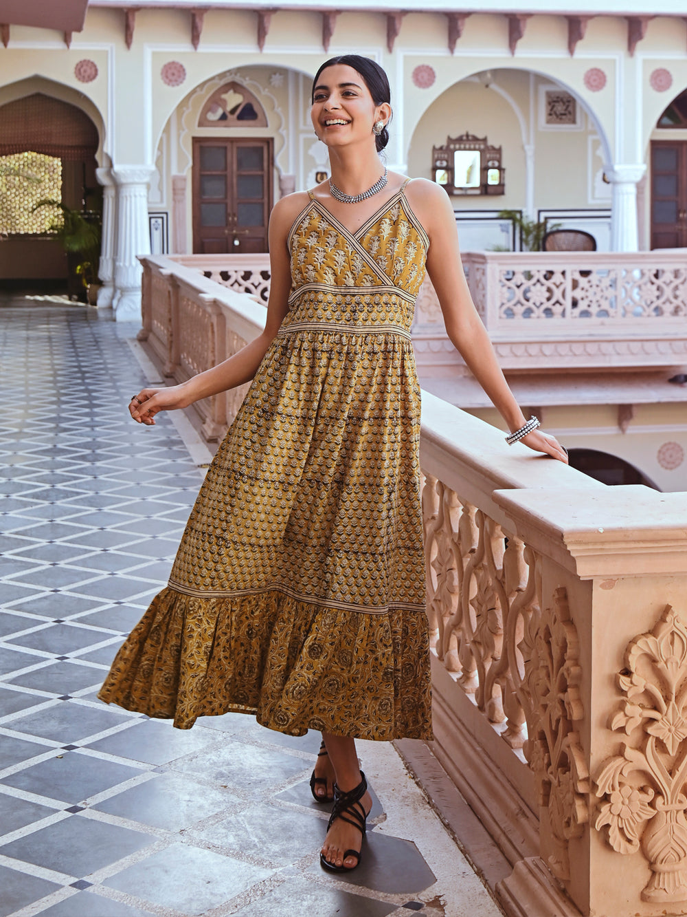 Woman posing in Savi's Cotton hand block inspired printed strappy mustard flared dress