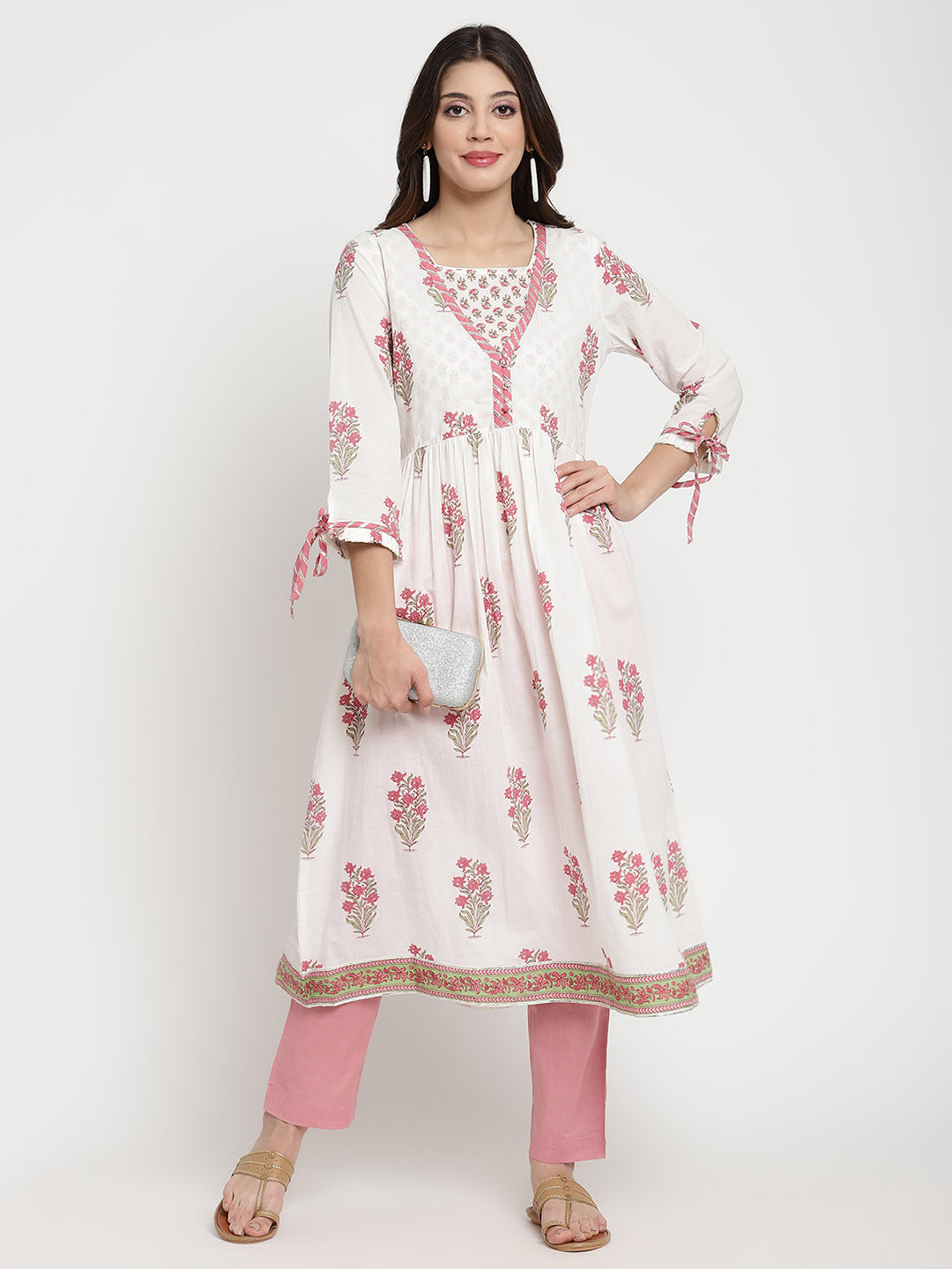 Woman posing in a white cotton Kurta that has a flared hemline. 